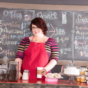 Redheaded fatty Kitten McPherson sports short hair and glasses while getting naked in a diner