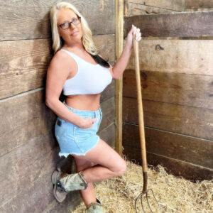 Blonde amateur Maddie Cross unveils her hefty tits while getting naked in a horse stall