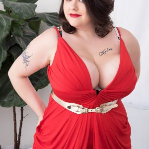 Tattooed BIG HOT LADY Nagini takes off a crimson dress while making her naked debut on a chesterfield