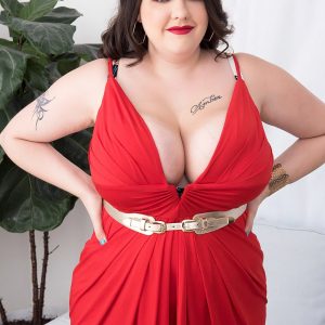 Tattooed BIG HOT LADY Nagini takes off a crimson dress while making her naked debut on a chesterfield